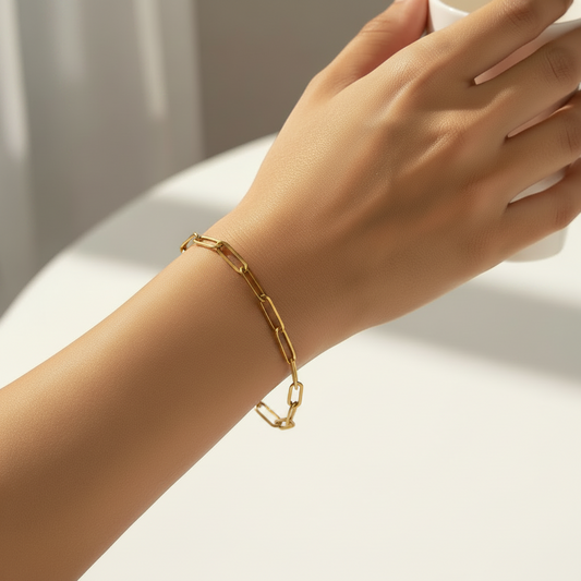 Gold paperclip chain bracelet on a white background