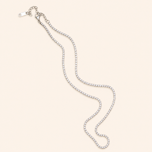 Silver chain necklace on a light beige background