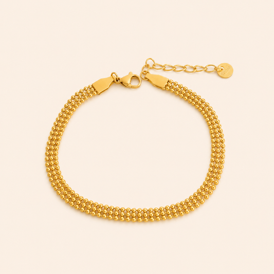 Gold bracelet on a beige background