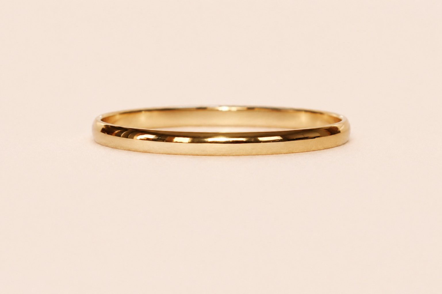 Gold bracelet on a beige background