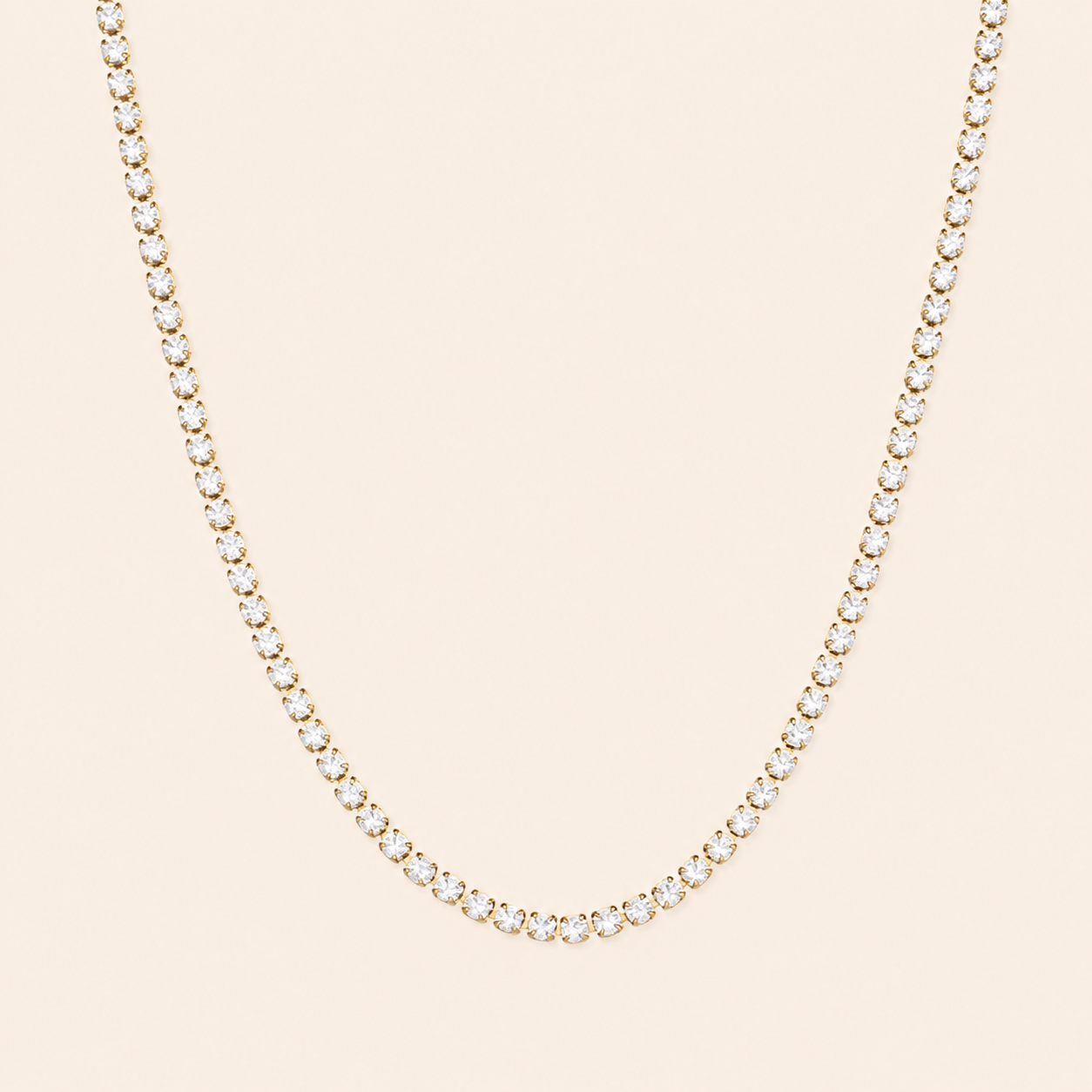 Delicate gold necklace with small diamonds on a beige background