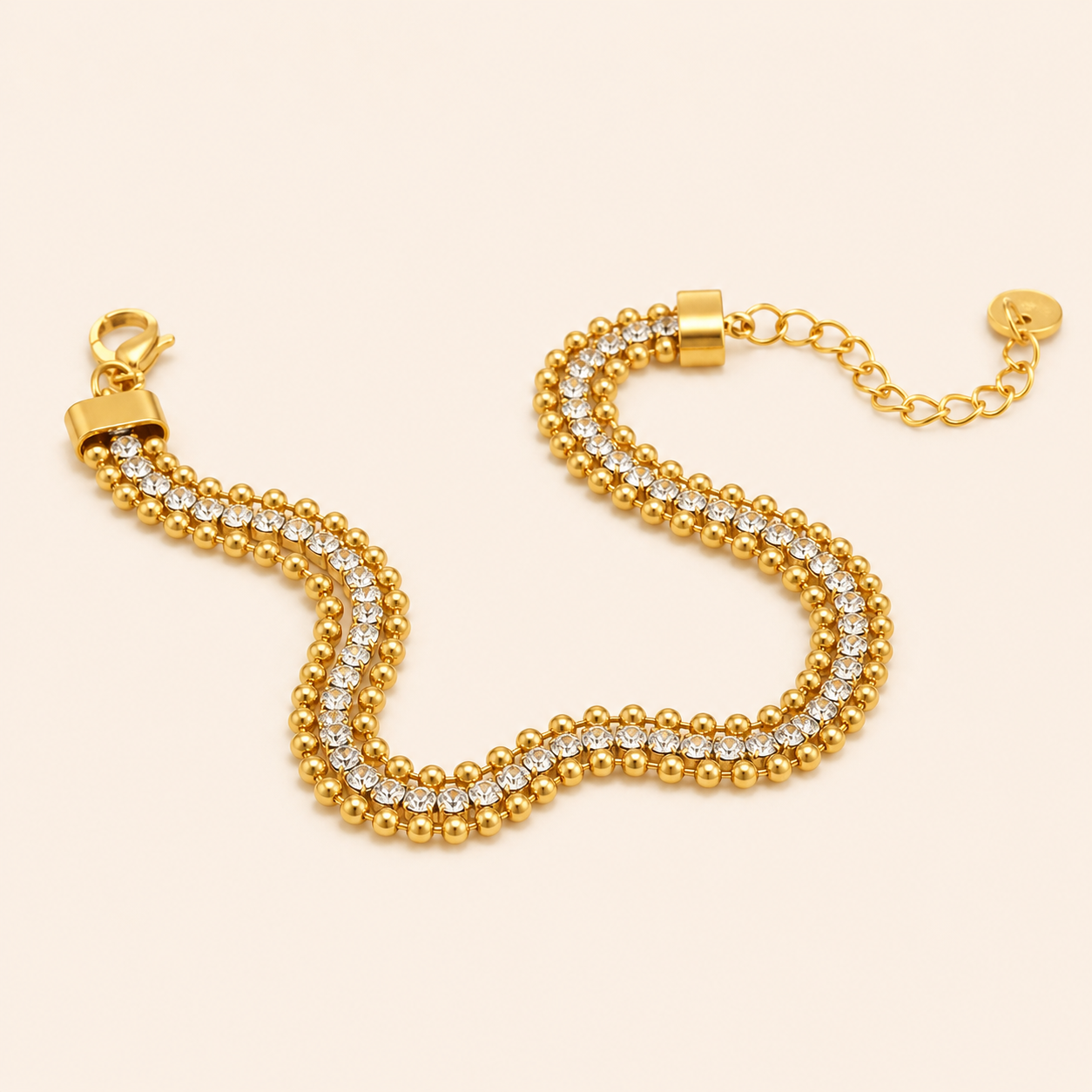 Gold bracelet with embedded crystals on a beige background
