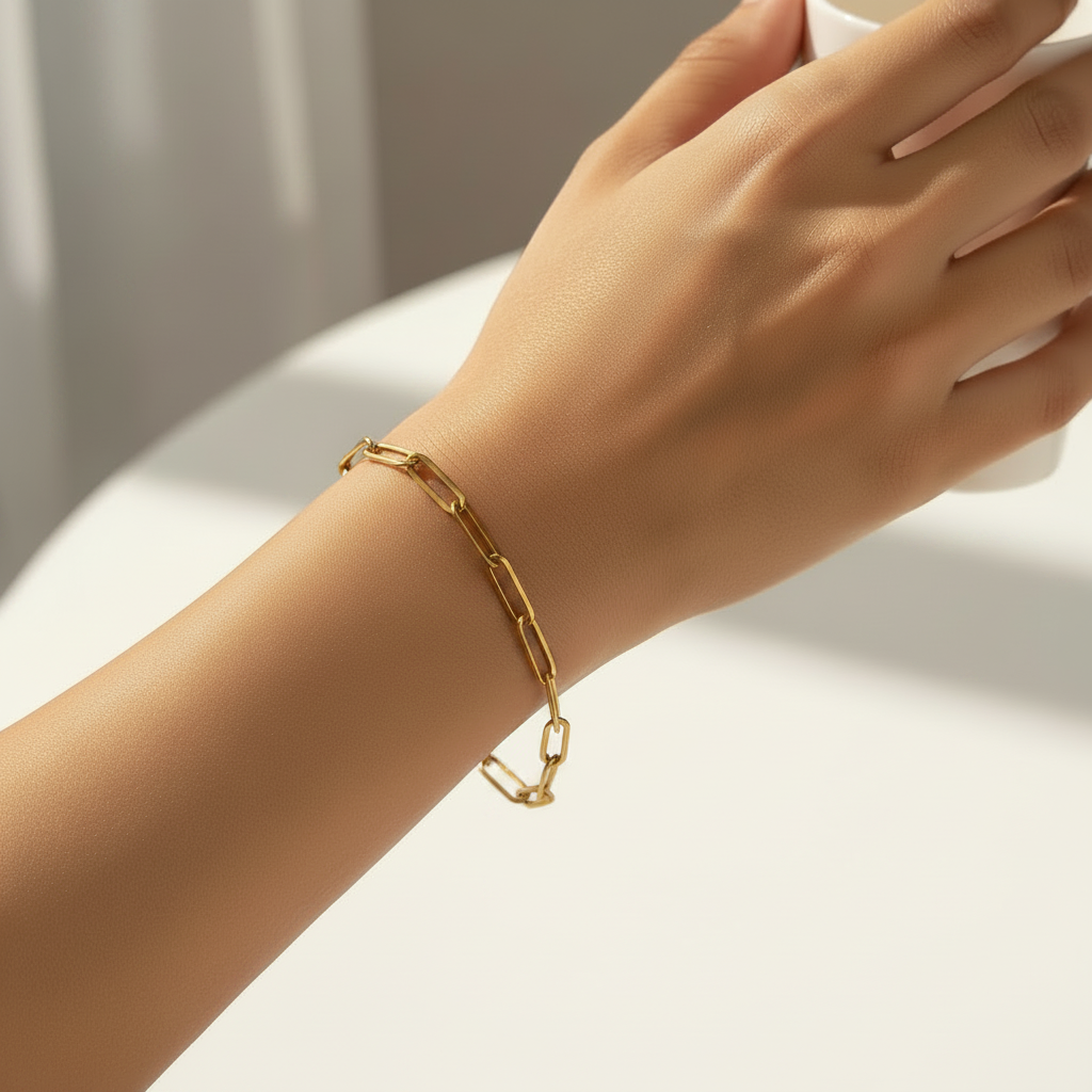 Gold paperclip chain bracelet on a white background