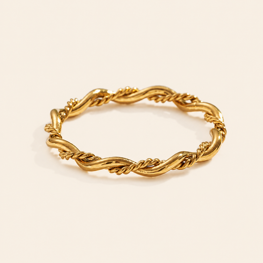Gold braided ring on a beige background