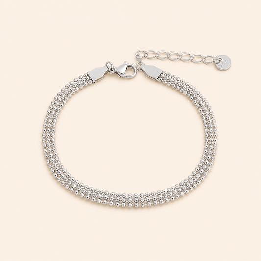 Silver bracelet with a clasp on a light beige background