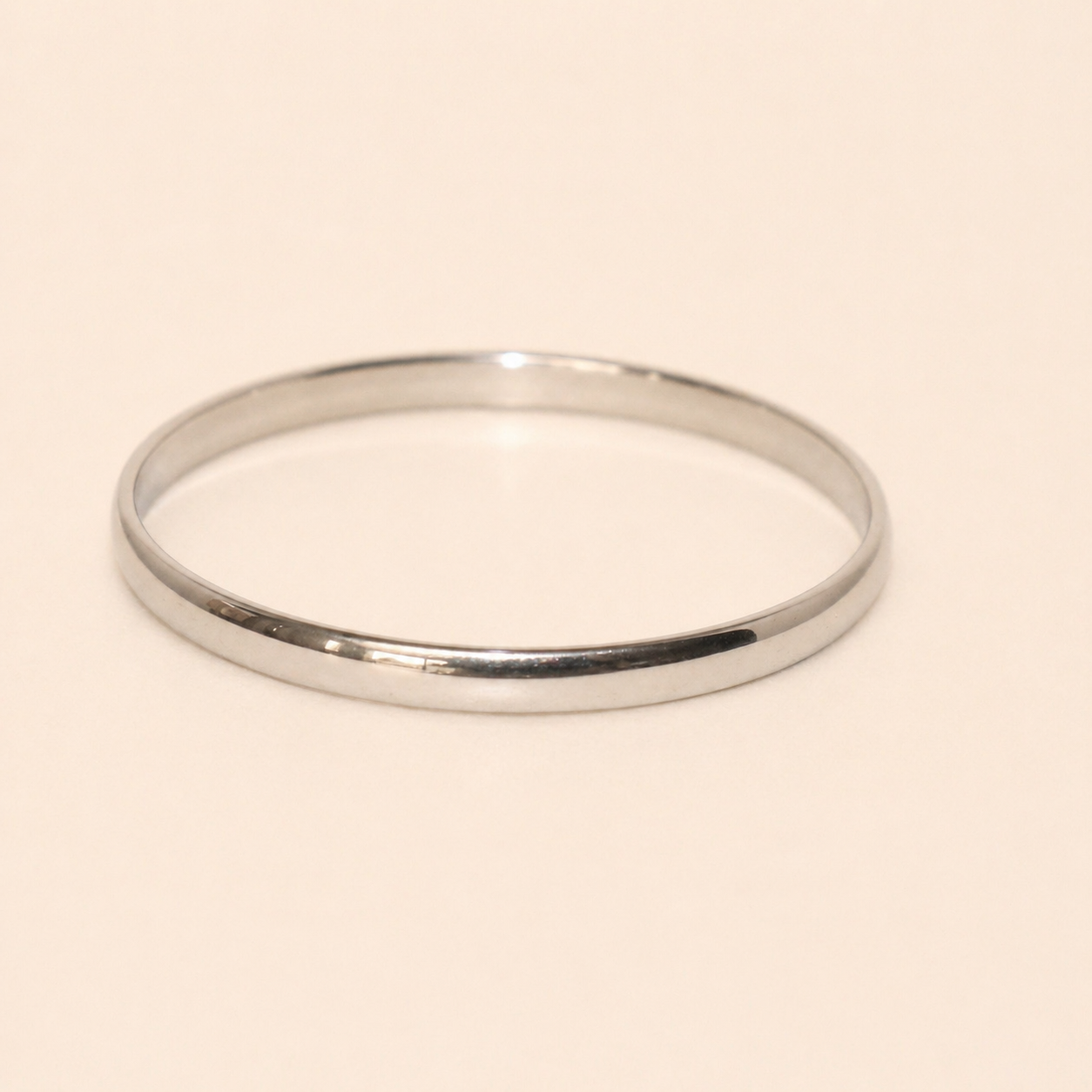 Silver bangle on a beige background