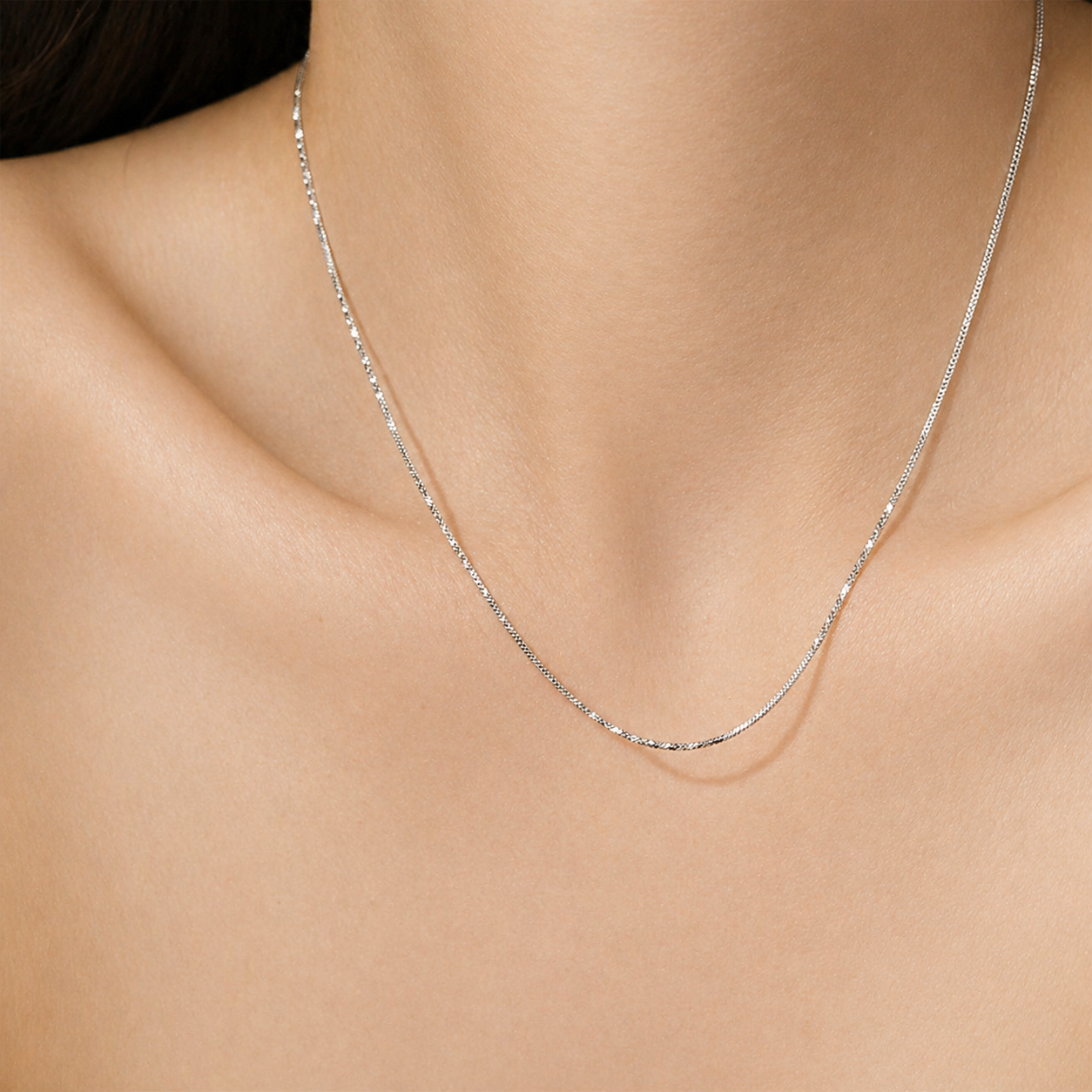 Silver necklace on a person's neck